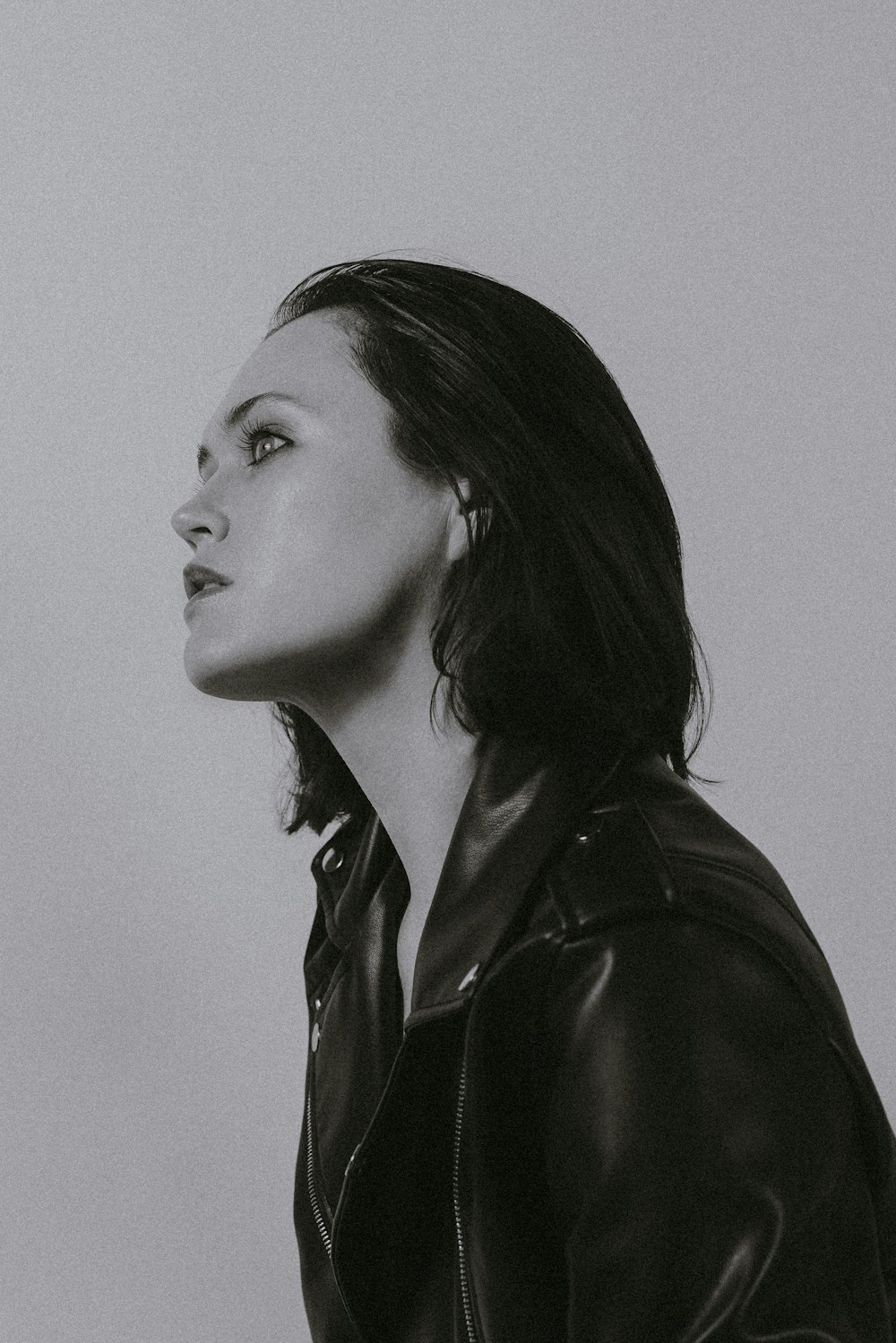 a black and white photo of a woman in a leather jacket