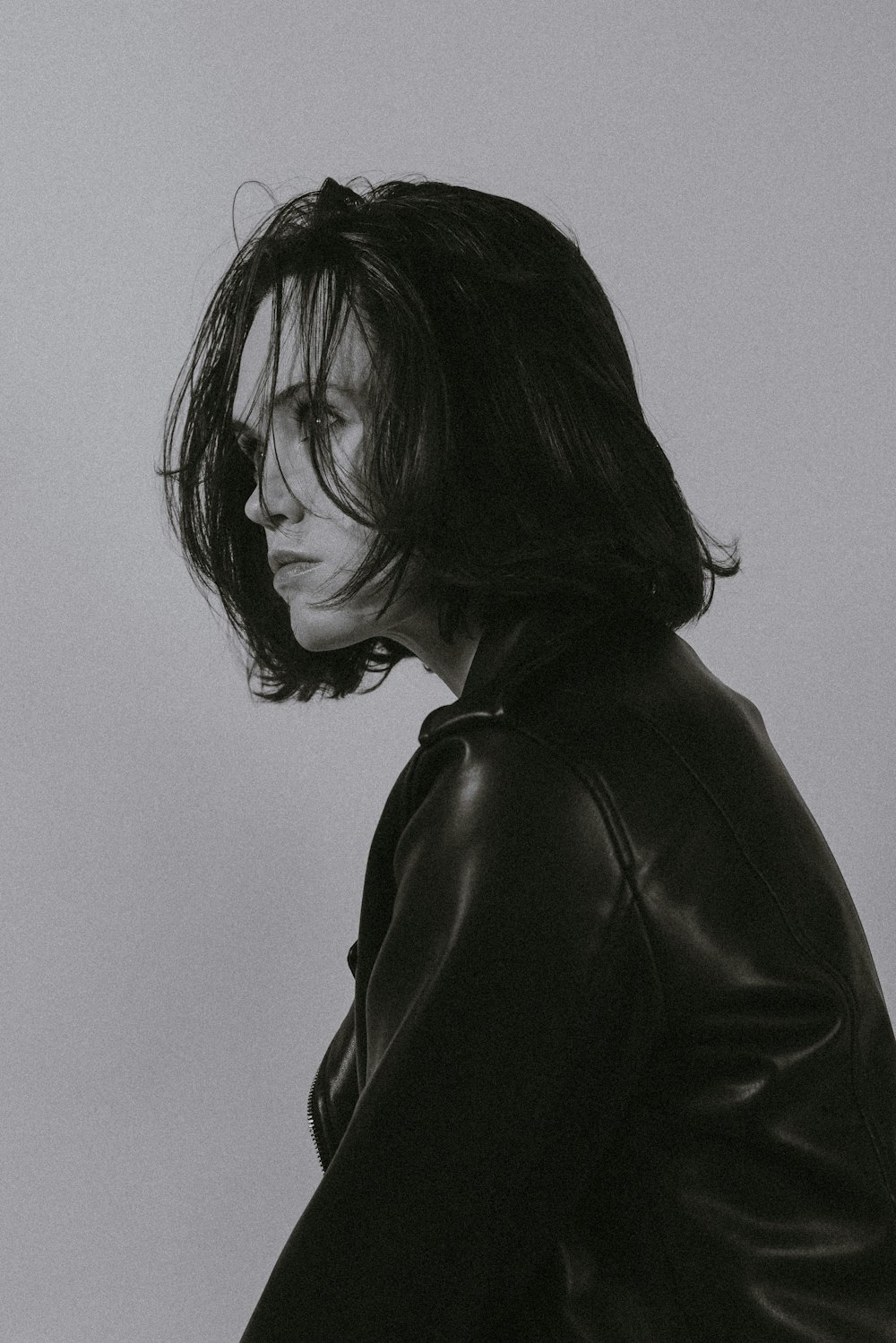 a black and white photo of a woman in a leather jacket