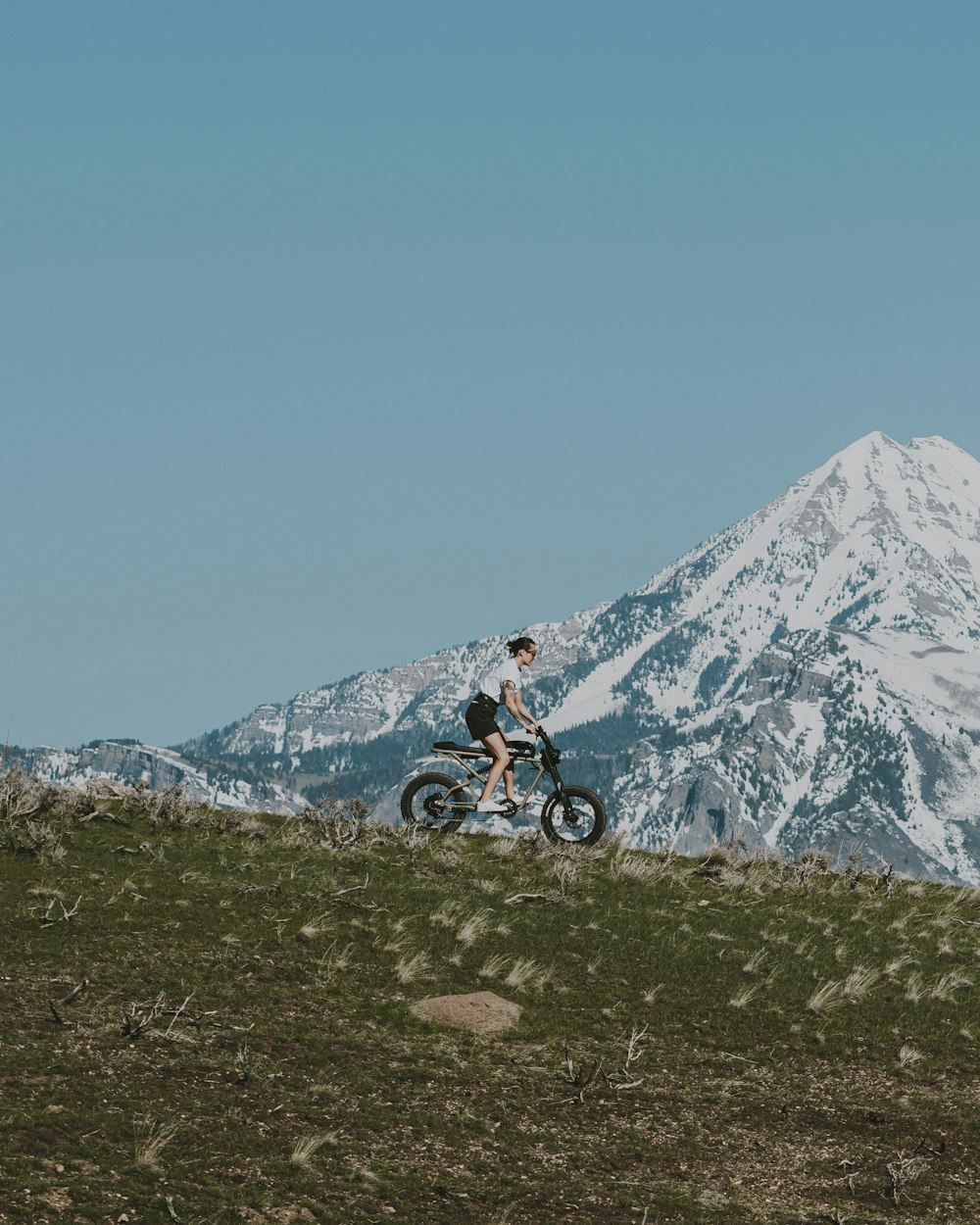 a man riding a dirt bike on top of a grass covered hill