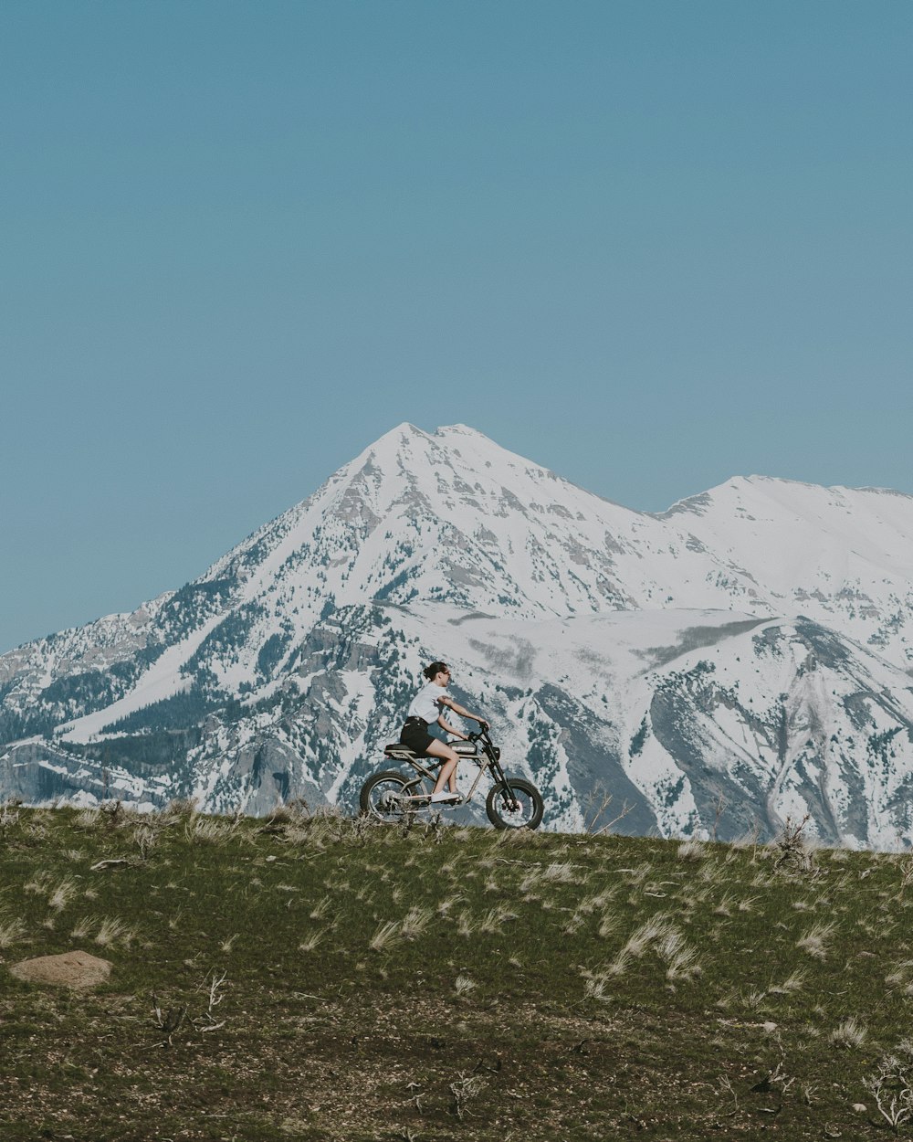 uma pessoa andando de bicicleta na frente de uma montanha