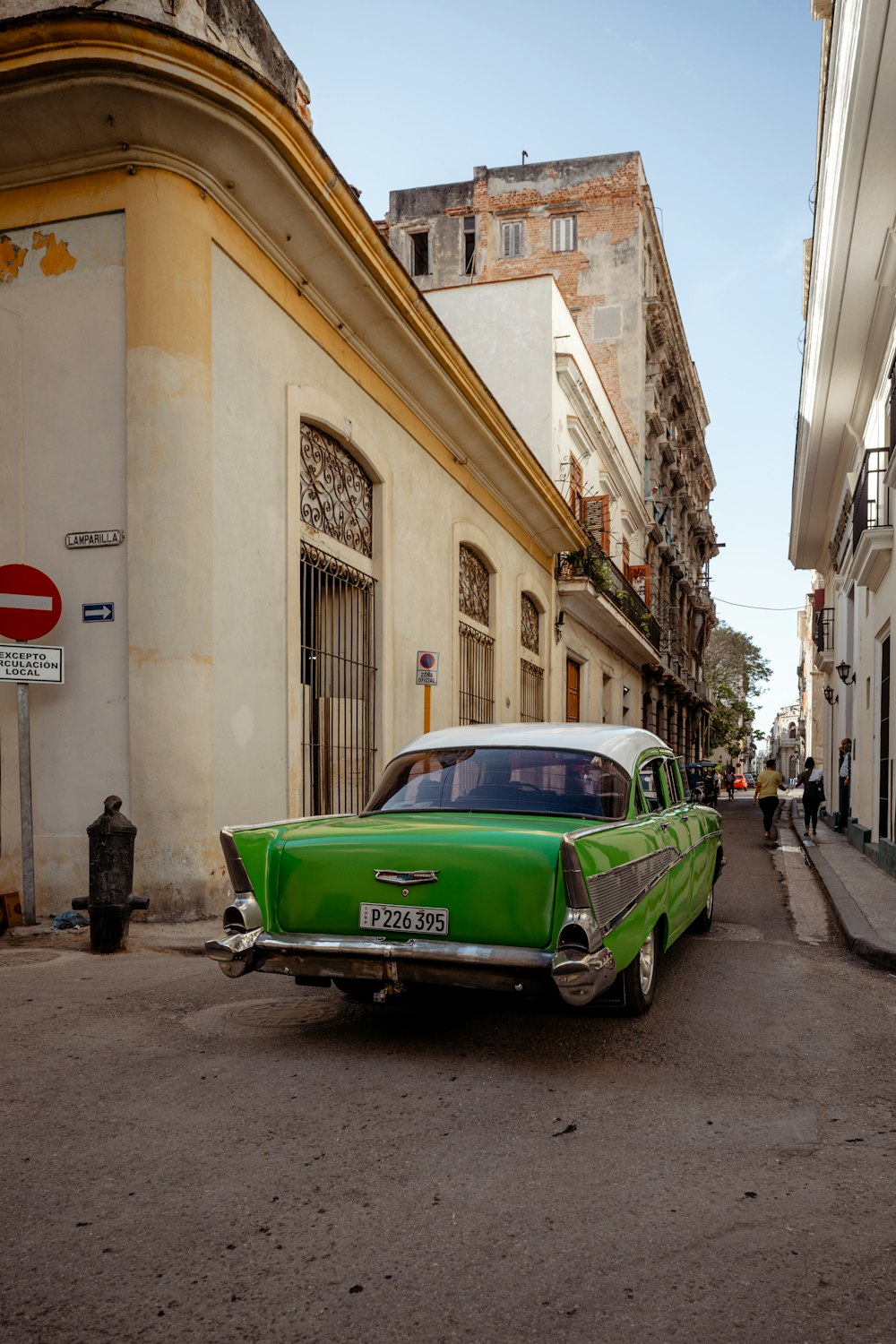 a green car parked on the side of the road