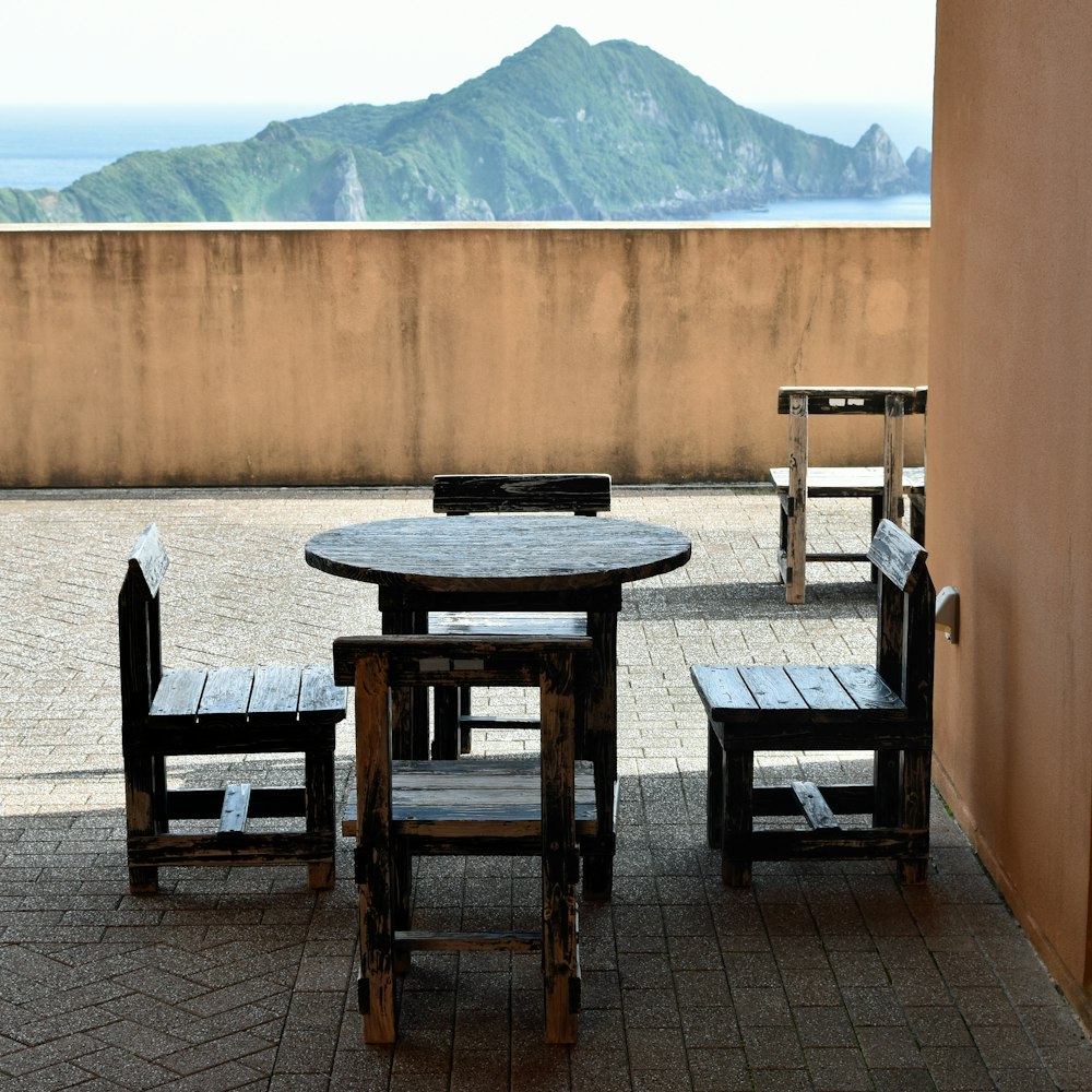 a table and chairs on a patio with a mountain in the background