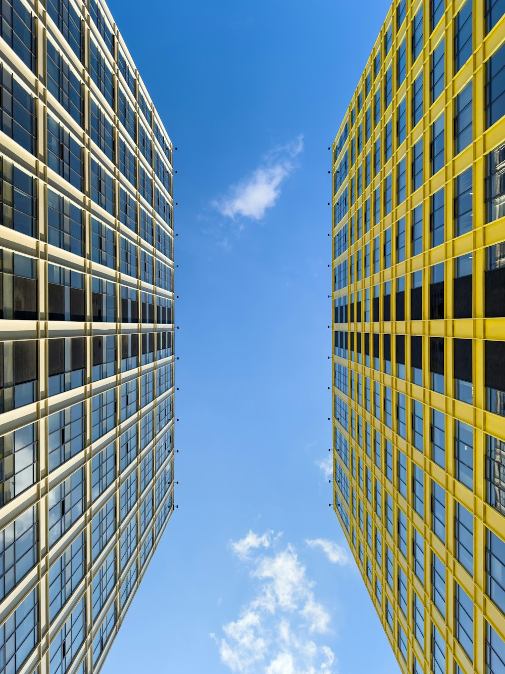 dois edifícios altos com janelas e um céu azul ao fundo