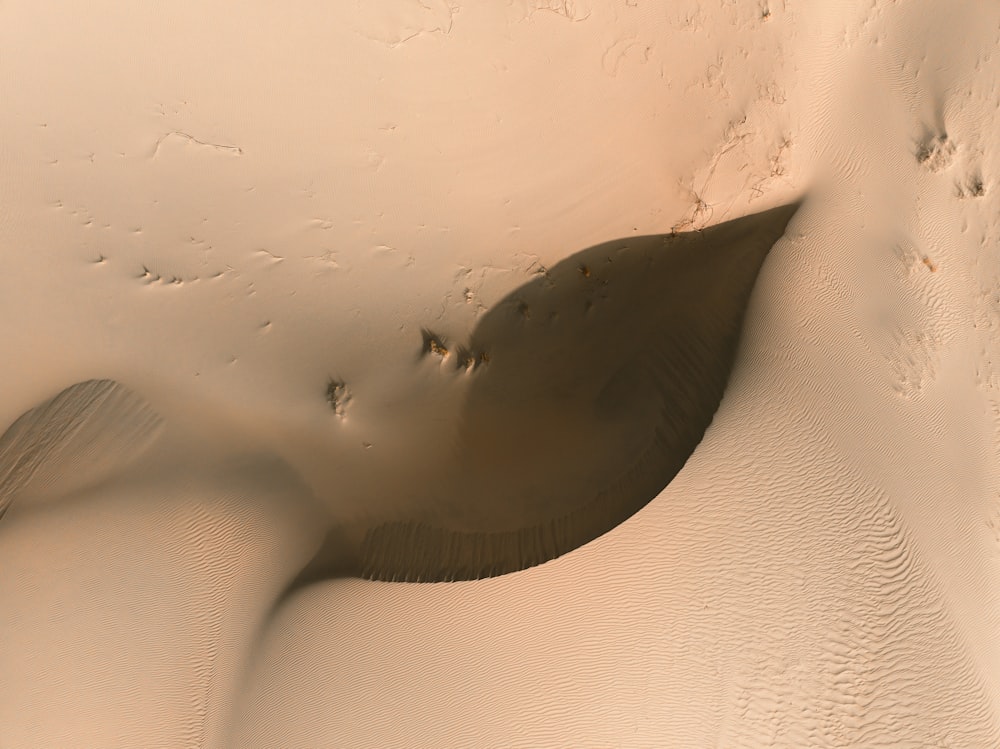 a sand dune with a small amount of sand blowing in the wind