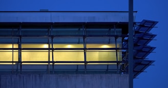 Evening shot of a building facade featuring blue and white aluminum window frames.