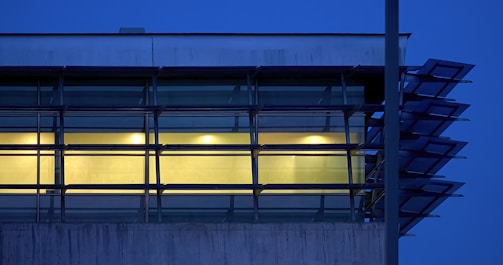 Evening shot of a building facade featuring blue and white aluminum window frames.