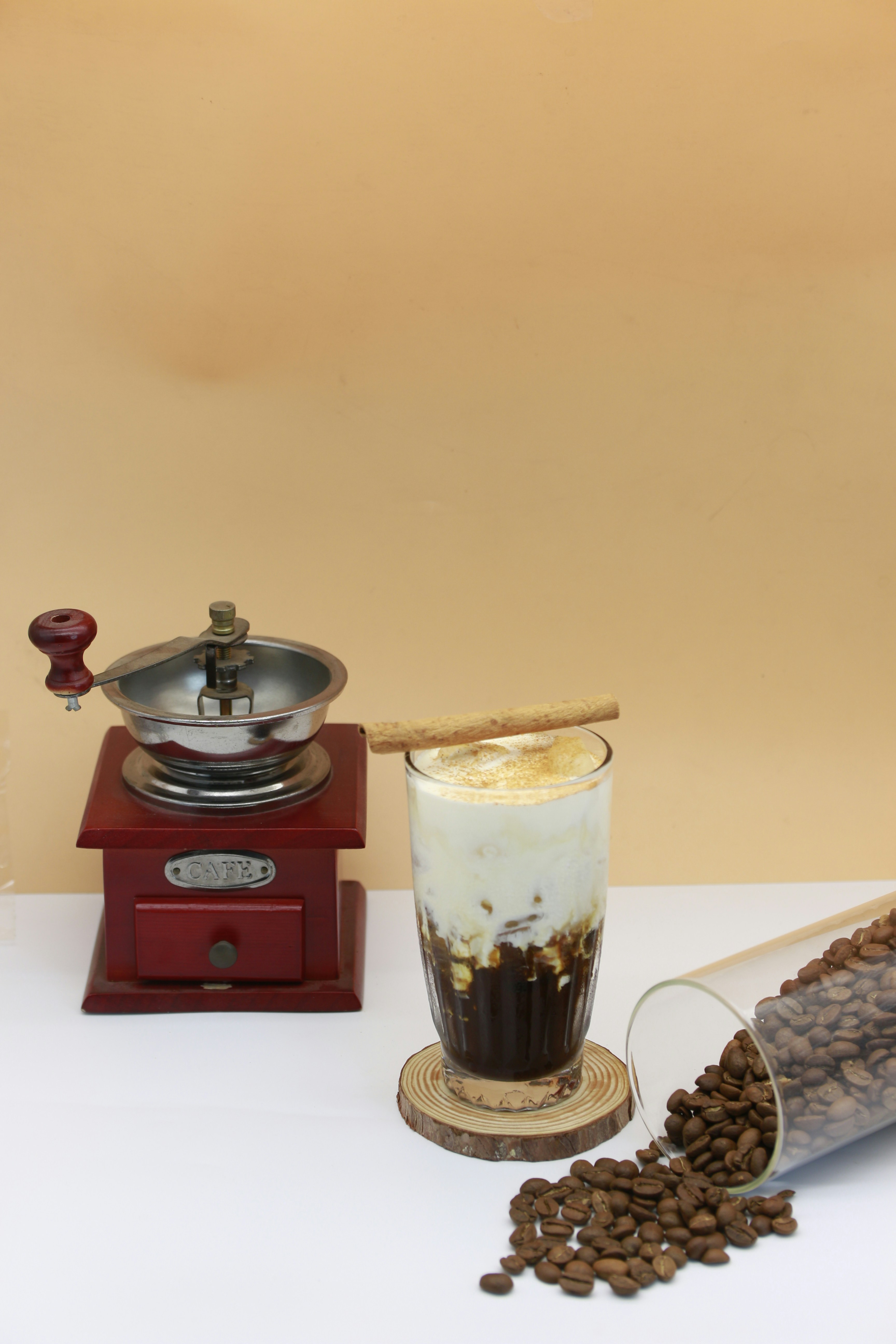 a cup of coffee next to a grinder and beans