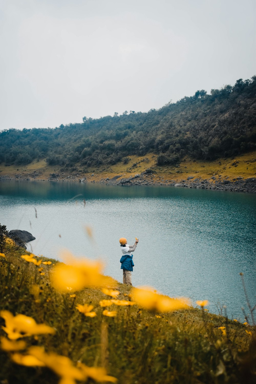 a person standing on a hill near a body of water