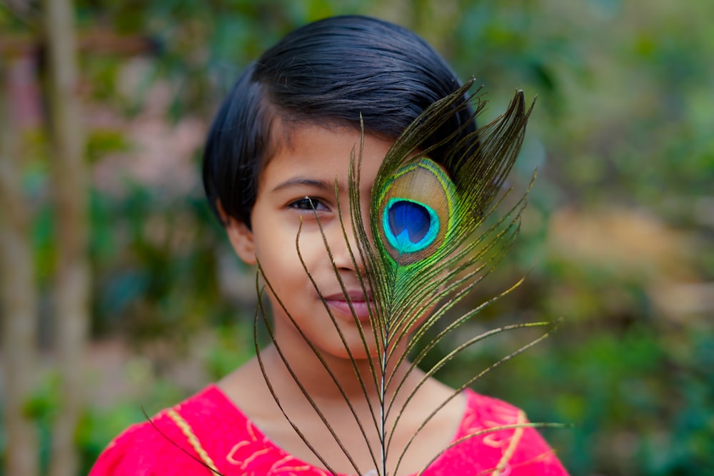 a young girl with a peacock feather on her head