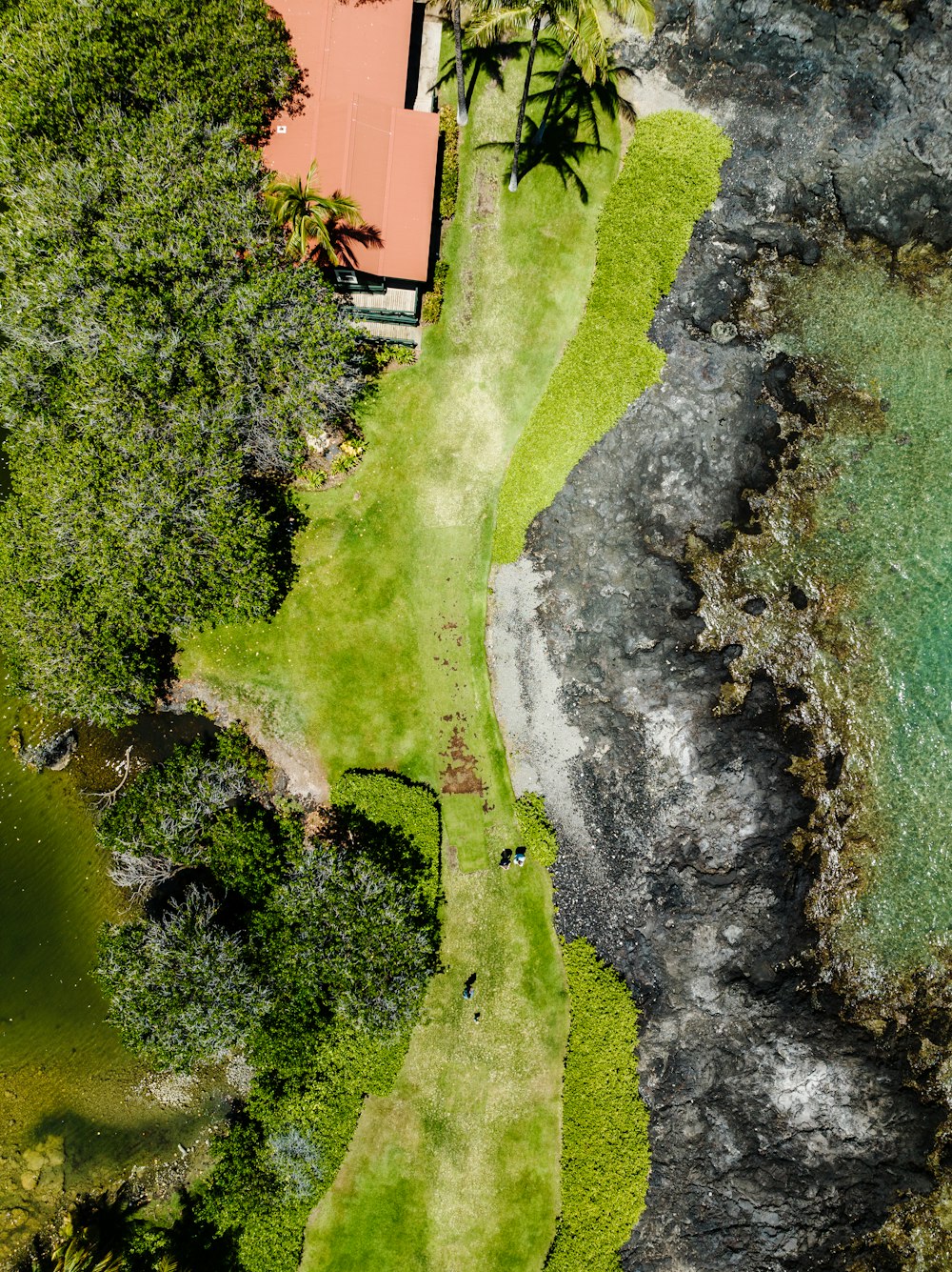 an aerial view of a golf course with a house in the background