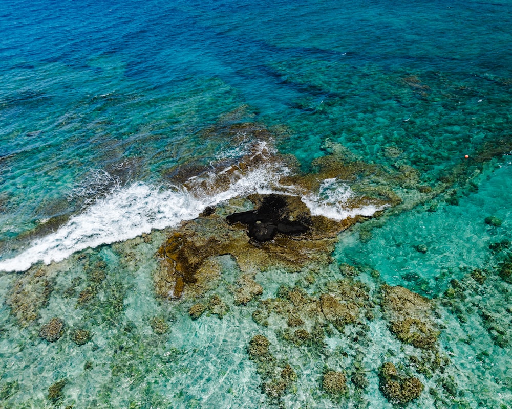 an aerial view of a rock formation in the ocean