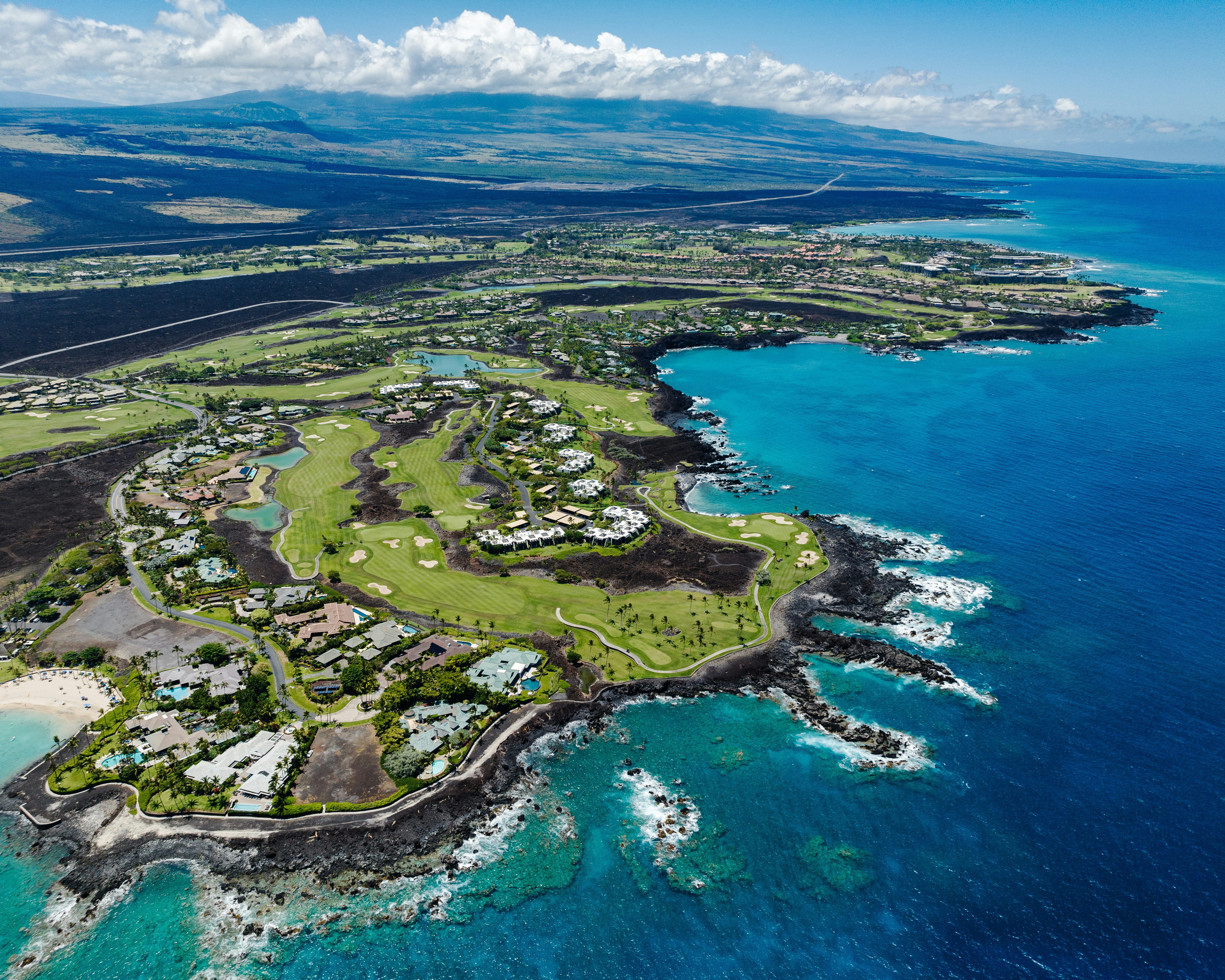 an aerial view of a golf course on the ocean, 