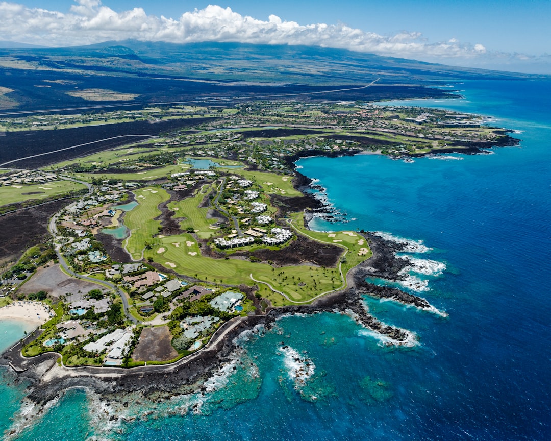 an aerial view of a golf course on the ocean,