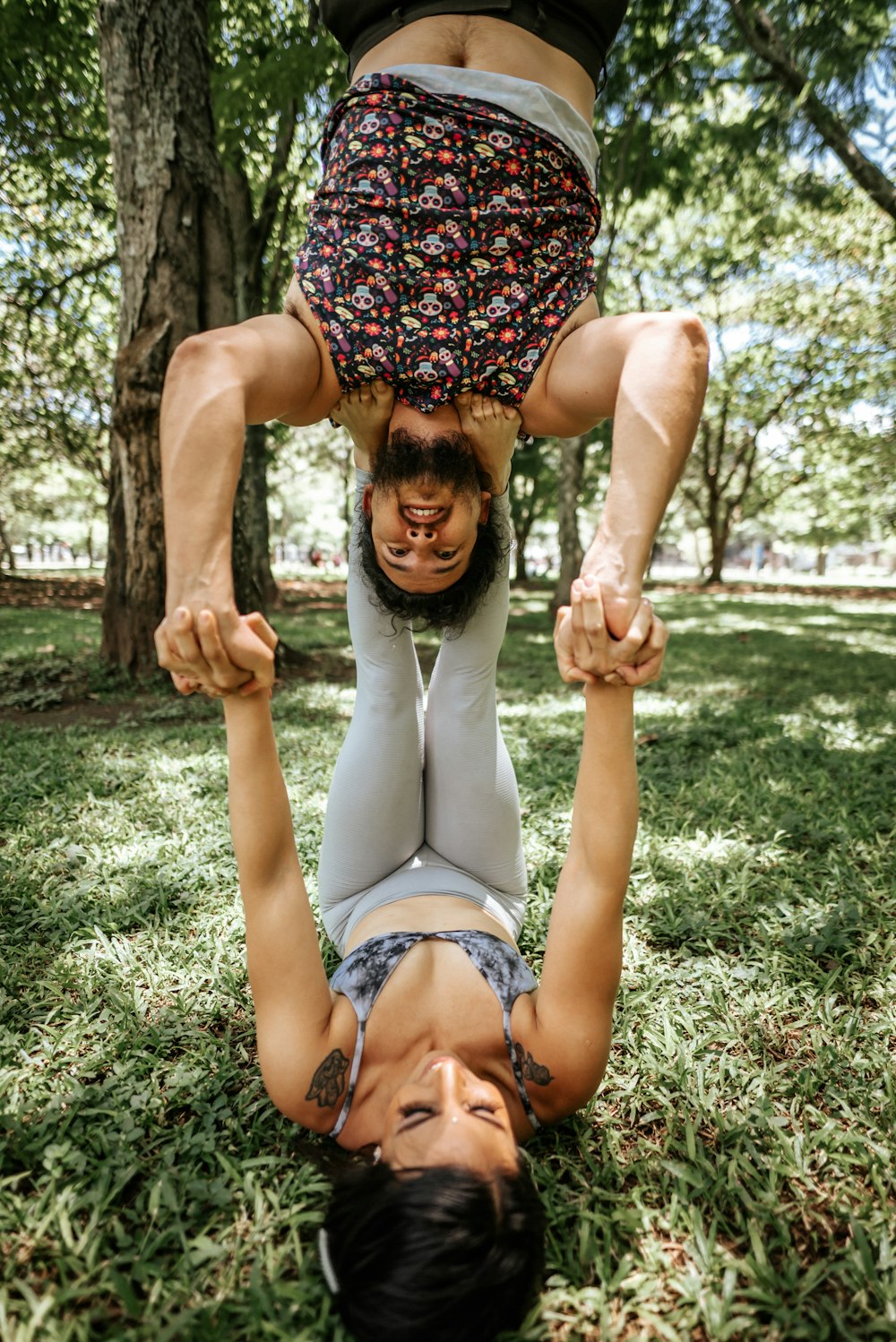 two people doing a handstand in the grass
