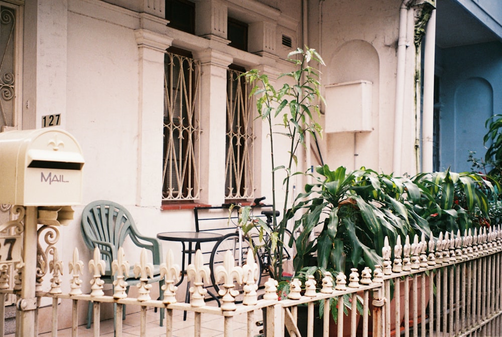 two chairs and a table on a sidewalk next to a building