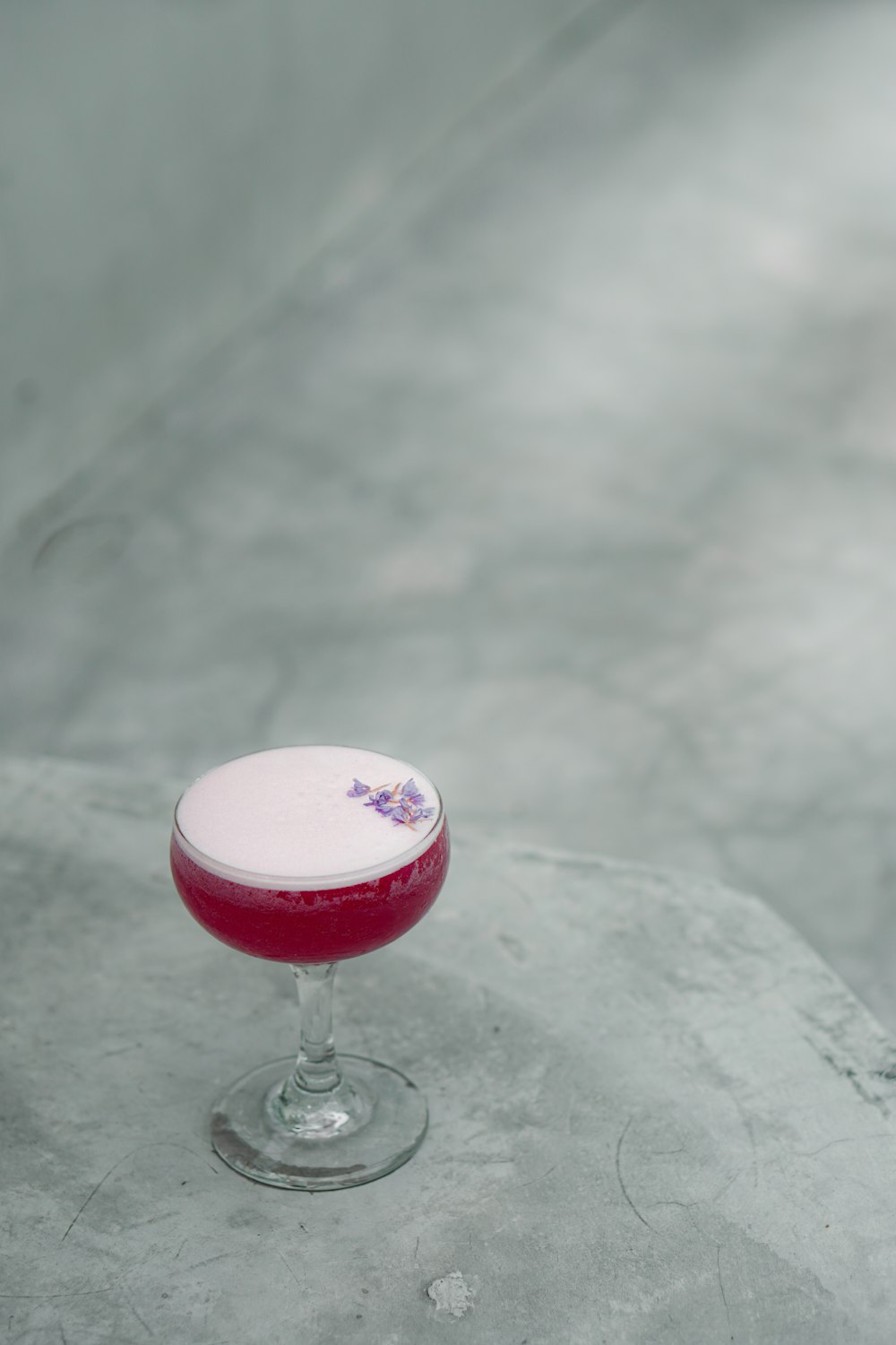 a small glass filled with a drink sitting on top of a table