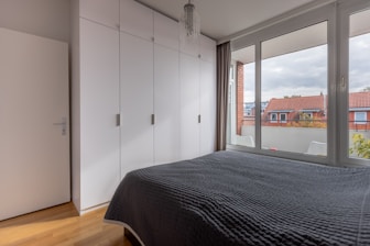 a bedroom with a bed and a large window