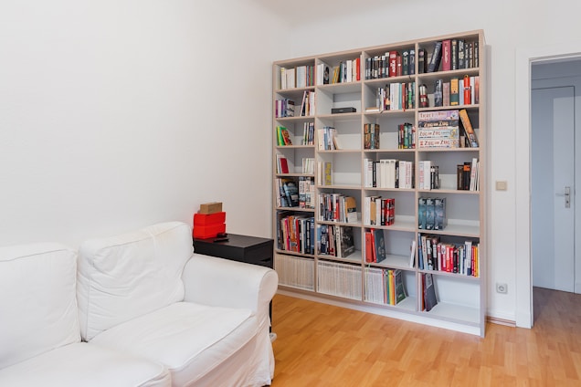 A bright, neatly organized living room with labeled storage bins and spotless surfaces reflecting careful cleaning and order.