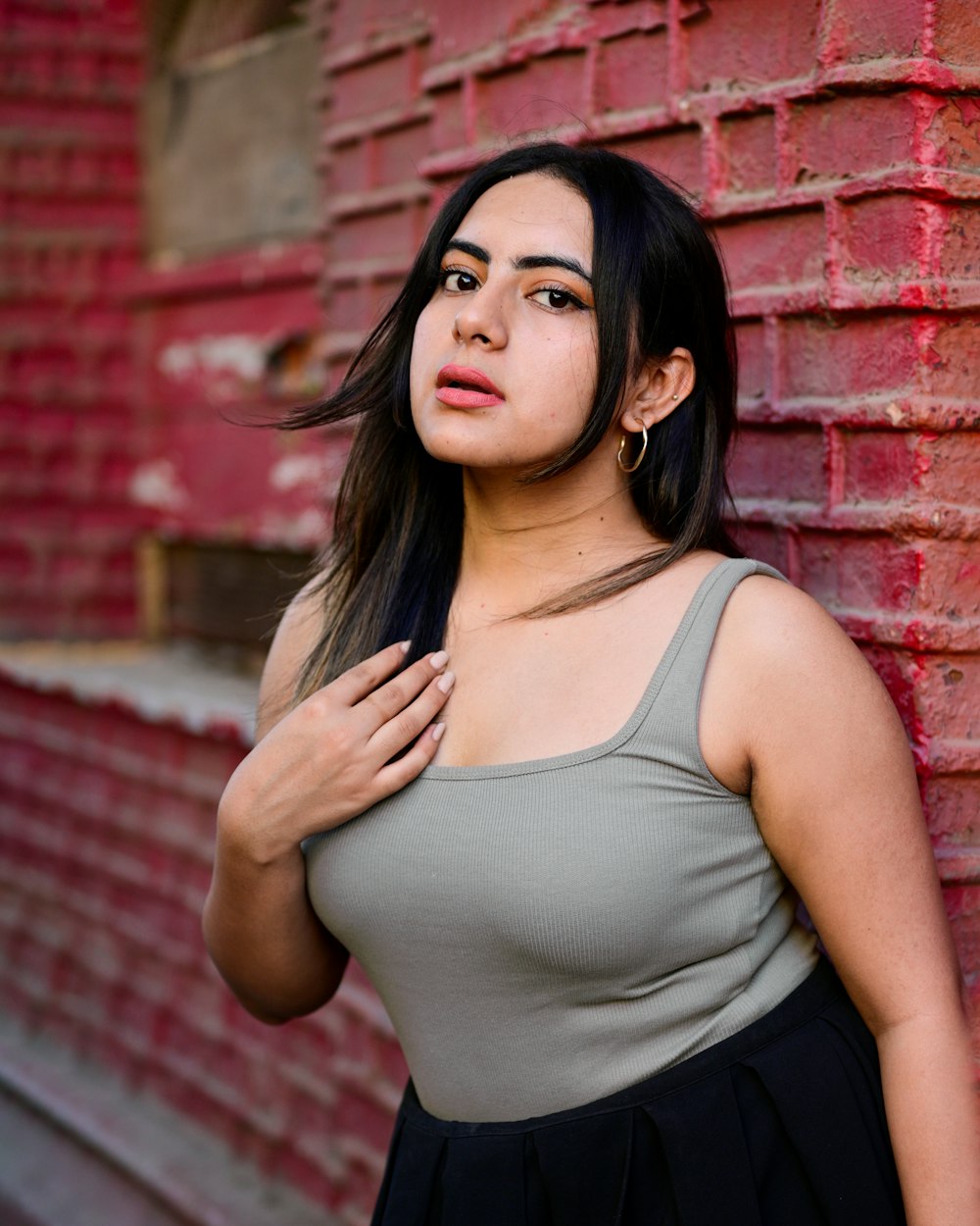 a woman standing in front of a brick wall