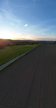 Expansive farmland with rich soil stretching towards a distant horizon at sunset.