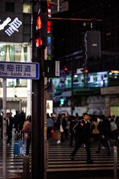 Bustling Shibuya Crossing at dusk with neon lights and crowds.