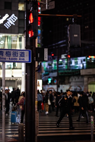 Night view of Shibuya crossing with neon lights and people crossing in all directions.