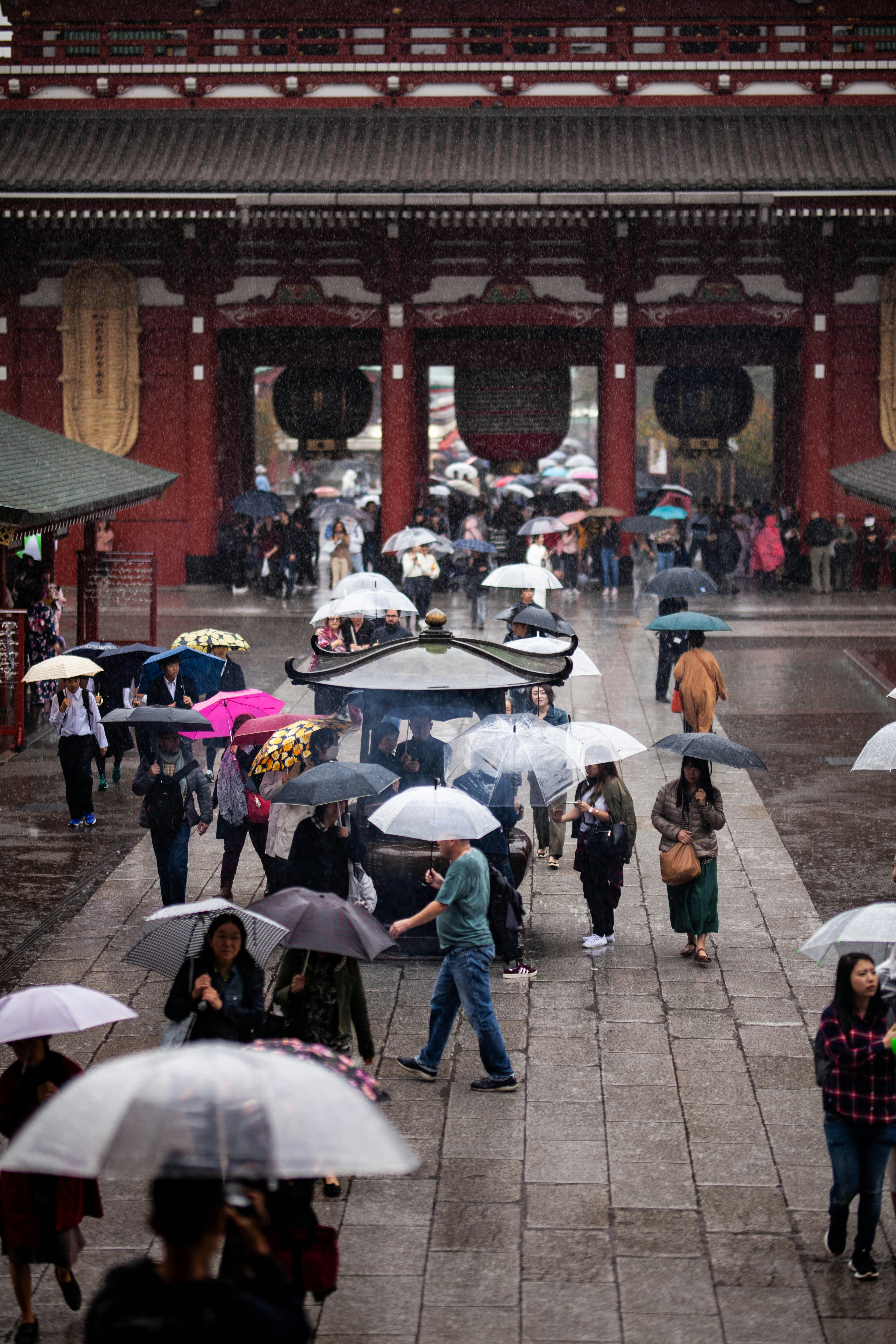 a group of people walking down a street holding umbrellas