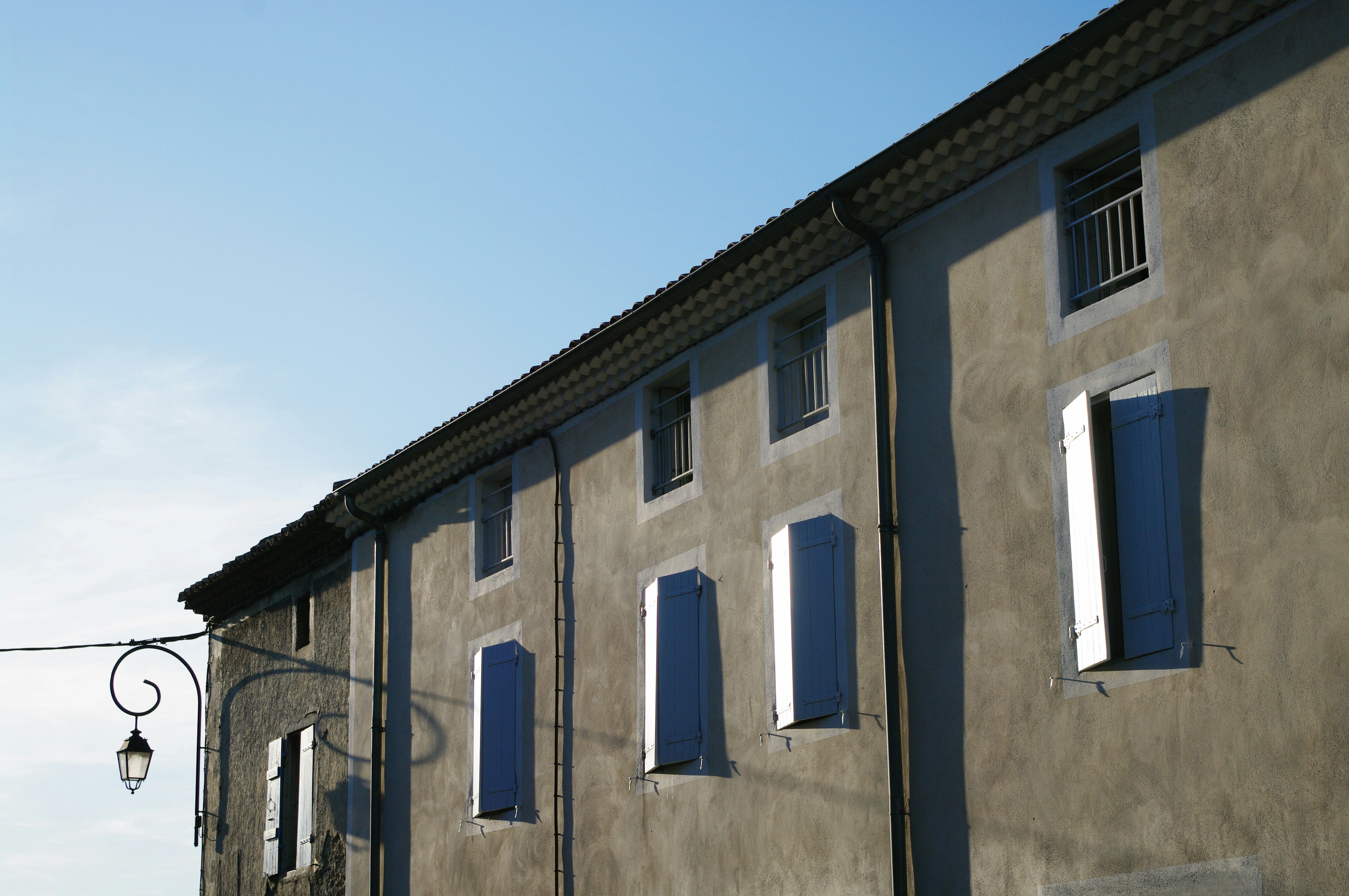 a building with blue shutters and a street light