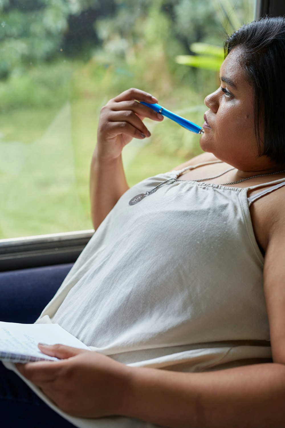 Una donna seduta in una macchina con carta e penna