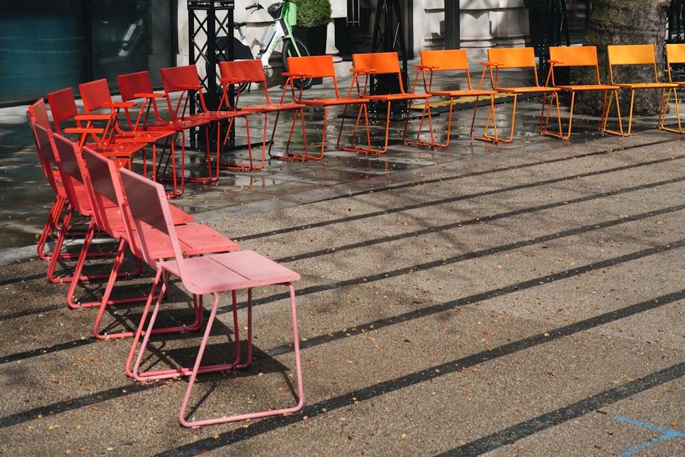 a row of red and orange chairs sitting next to each other