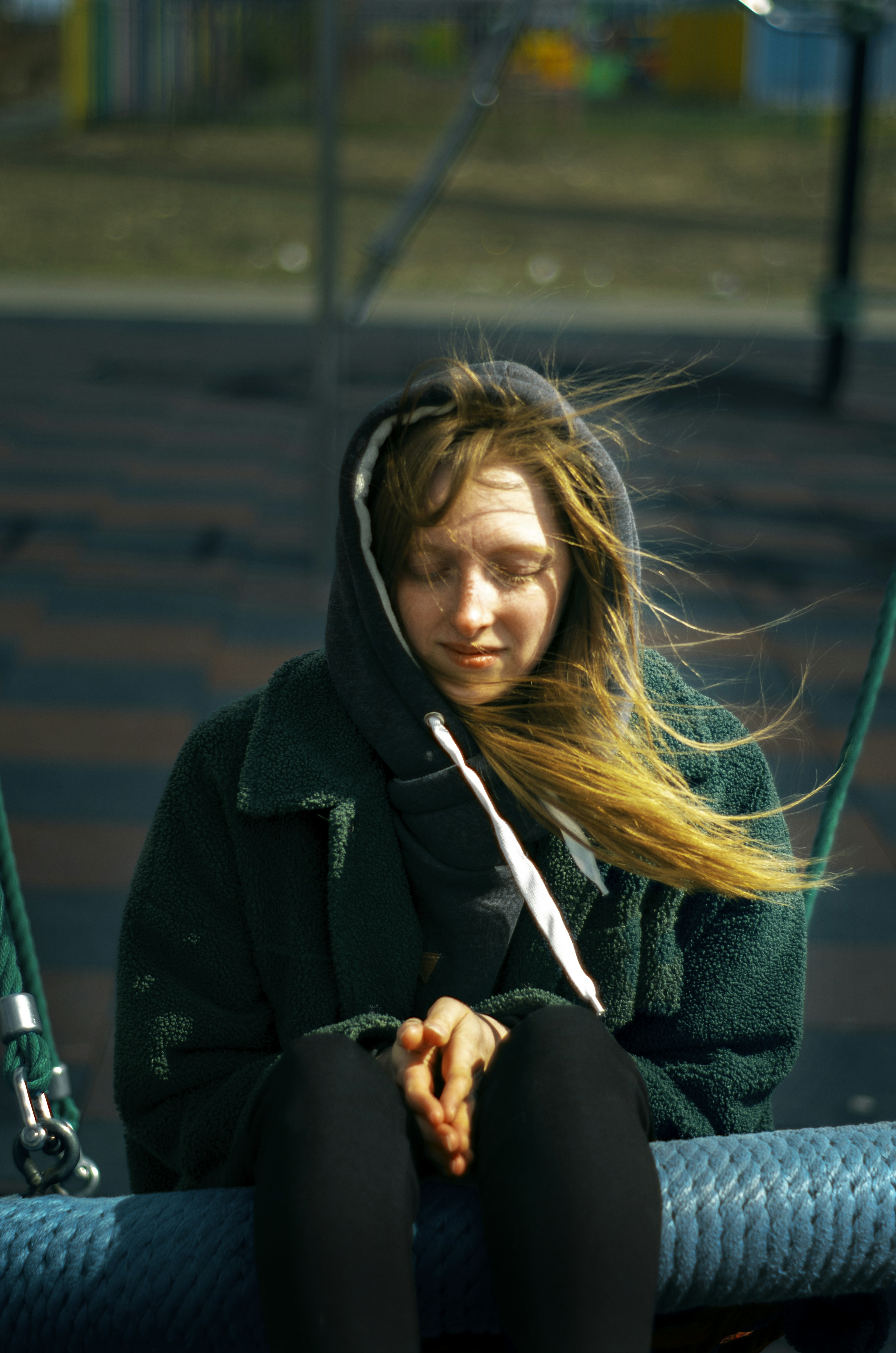 a woman with long hair sitting on a bench