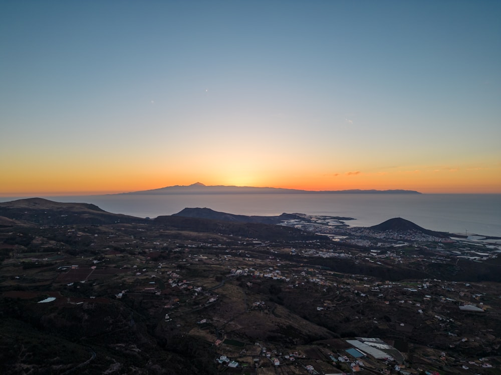 the sun is setting over a small town