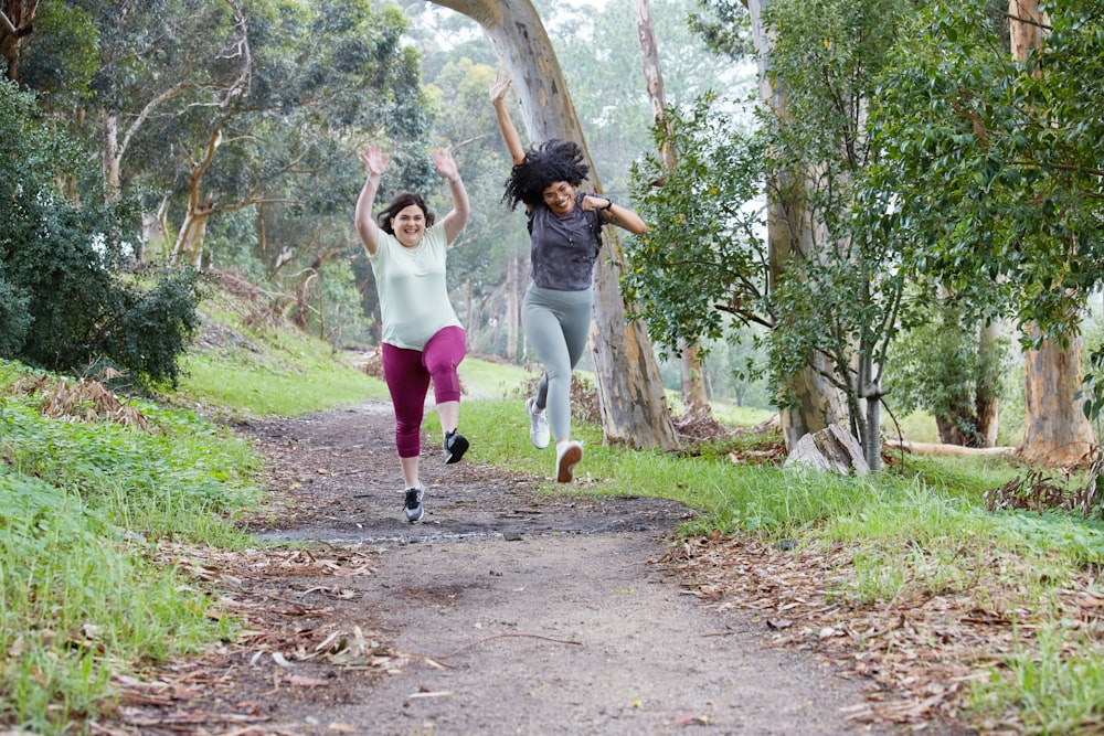 two women running down a path in the woods