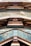 The image features the interior view of a modern architectural structure with reflective metal surfaces and glass panels. The design incorporates geometric shapes and angles, creating a visually dynamic pattern with reflections and light plays.