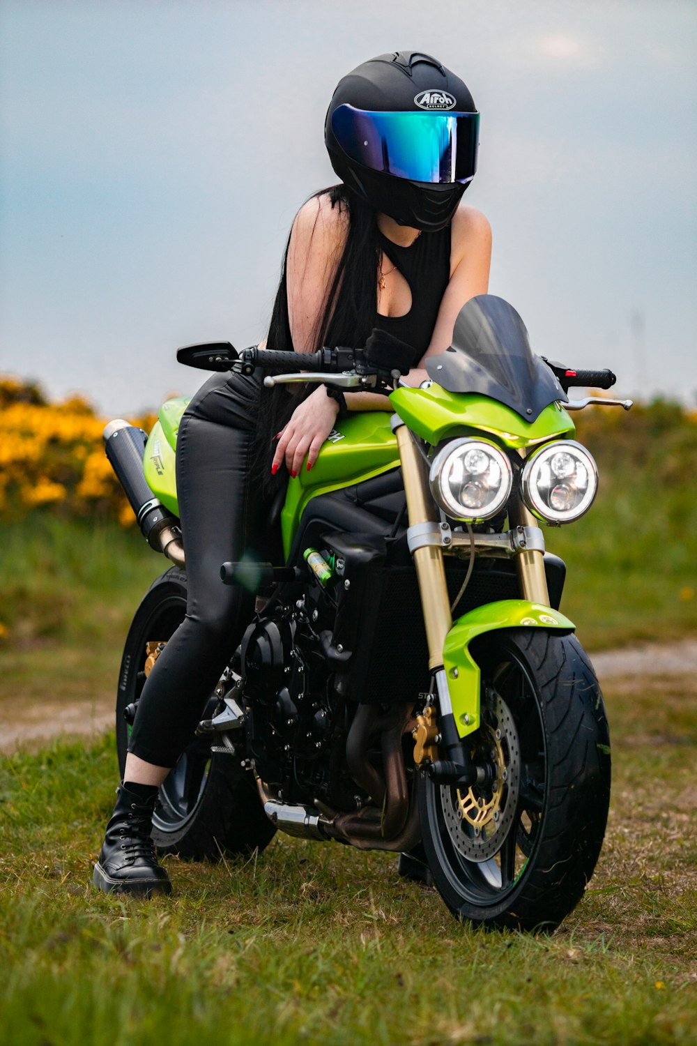 a woman sitting on top of a green motorcycle