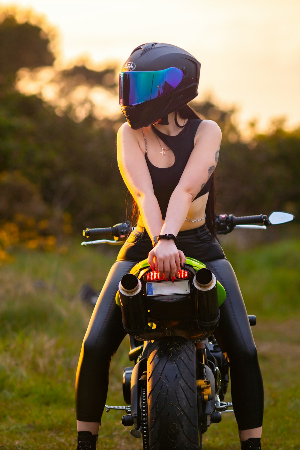 a woman sitting on a motorcycle with a helmet on