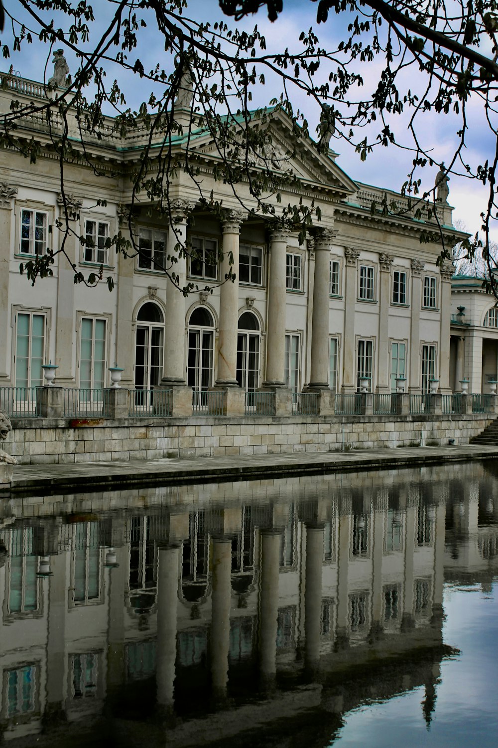 Un grande edificio bianco seduto accanto a uno specchio d'acqua