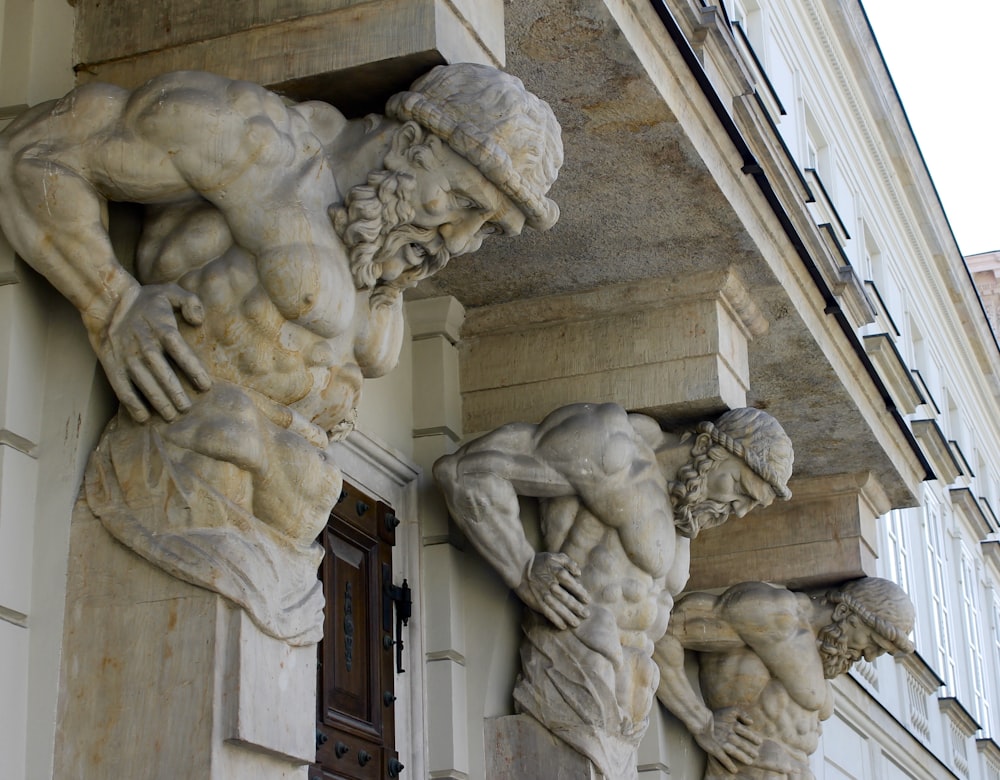 un paio di statue sul lato di un edificio