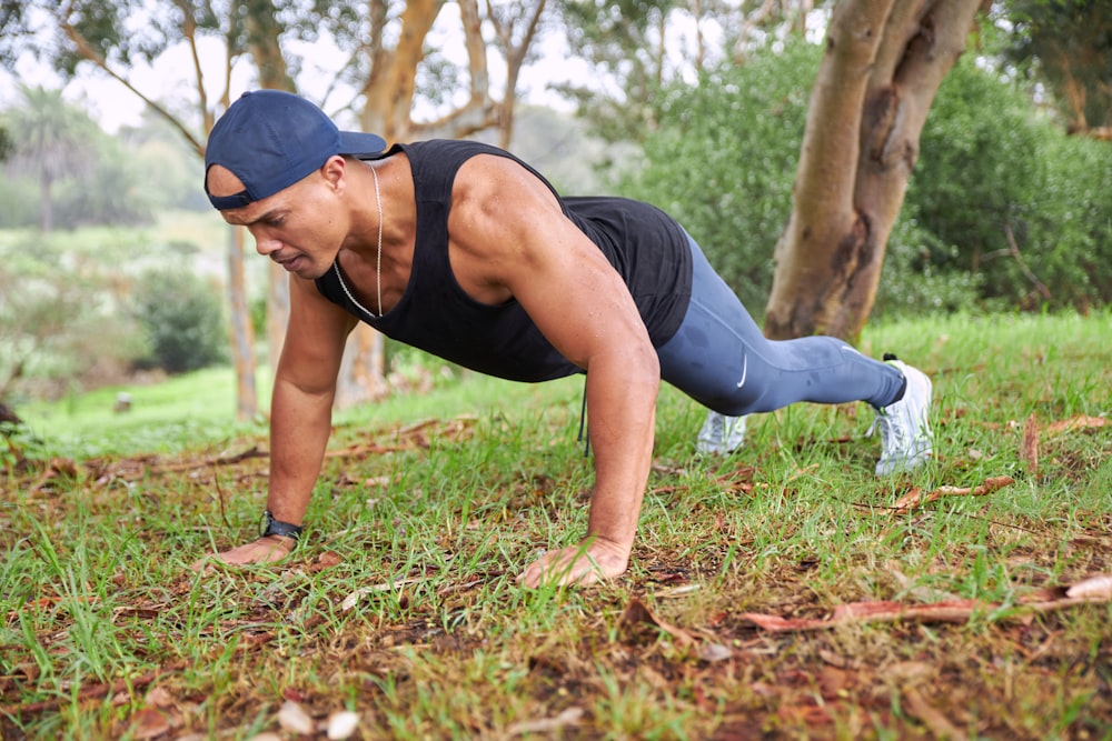 Un hombre está haciendo flexiones en la hierba