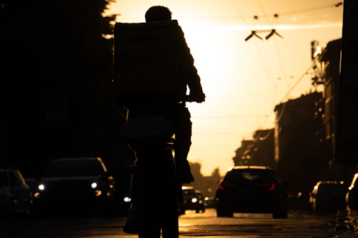 CycleLift vehicle driving away from a corporate loading bay at sunset.