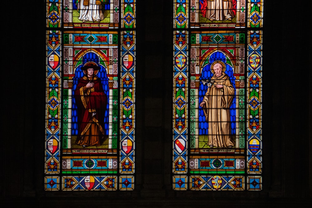 two stained glass windows in a dark room