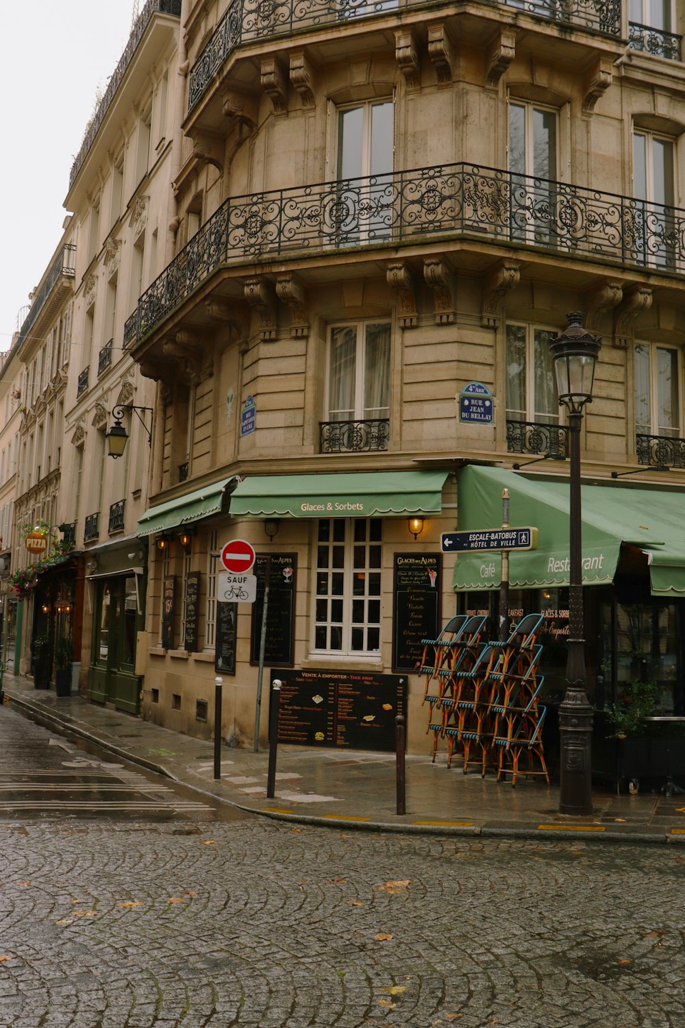 a building with a green awning on a street corner