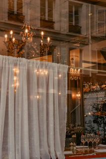 Elegant sheer drapes framing a cozy dining hall bathed in warm evening light.