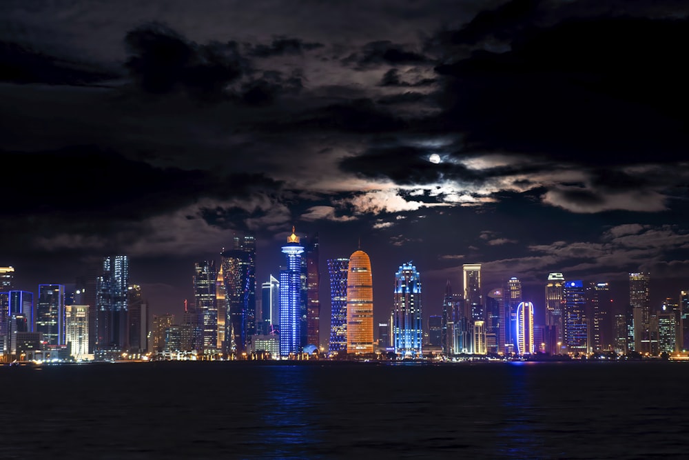 a city skyline with a full moon in the sky