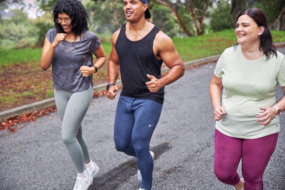 a group of three people running down a road