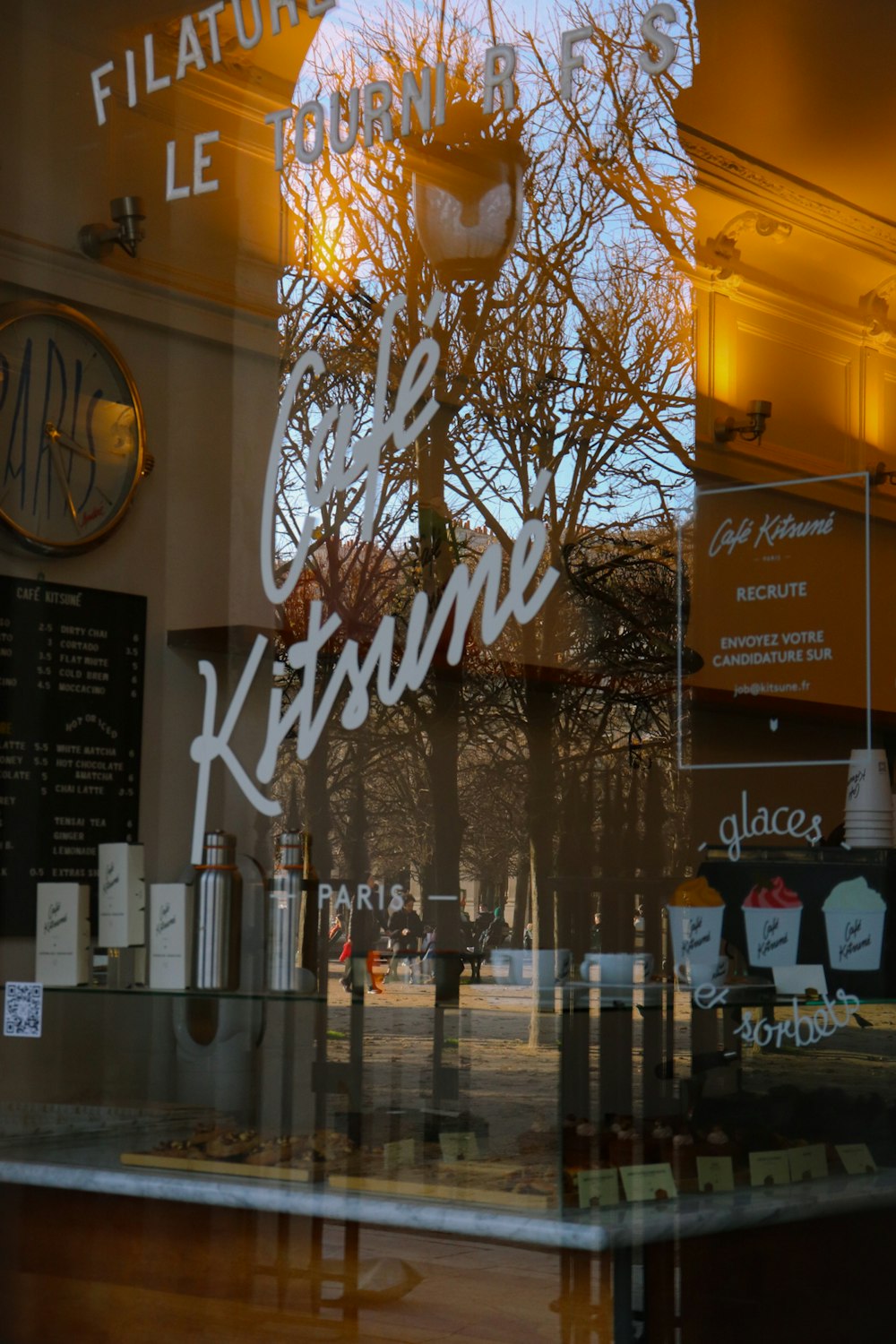 El reflejo de un reloj en la ventana de un restaurante