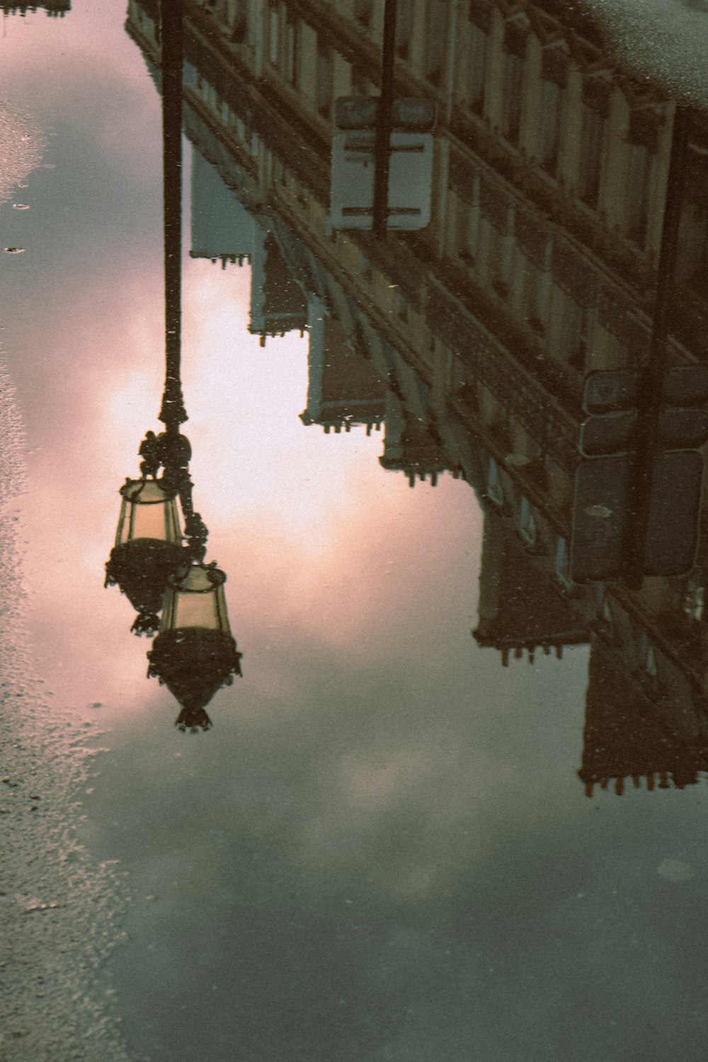 a street light reflecting in a puddle of water