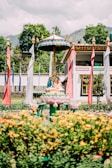 A peaceful temple courtyard with golden statues and blooming lotus flowers.