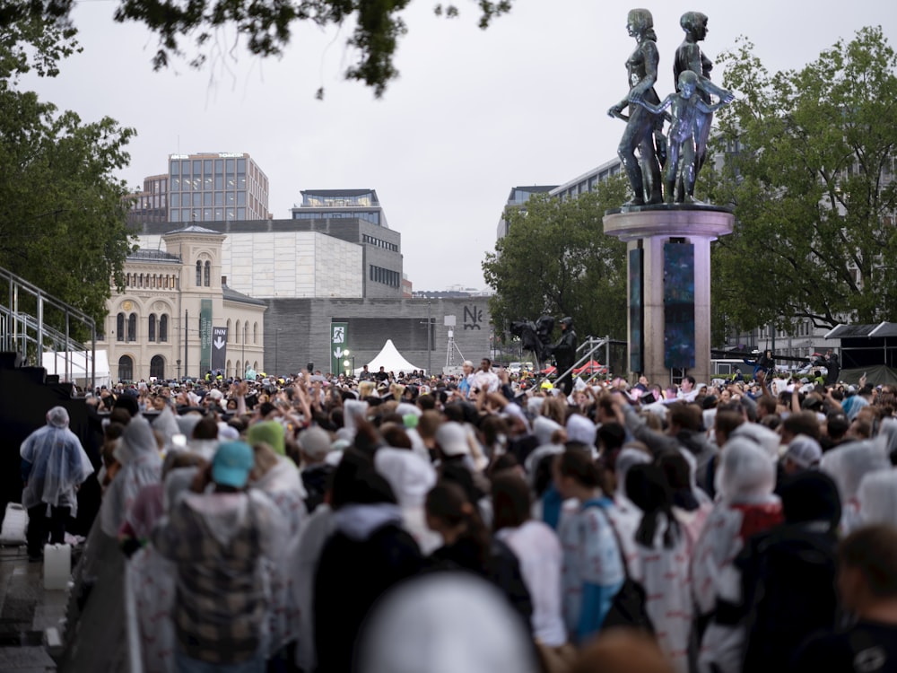 a large group of people standing in front of a statue