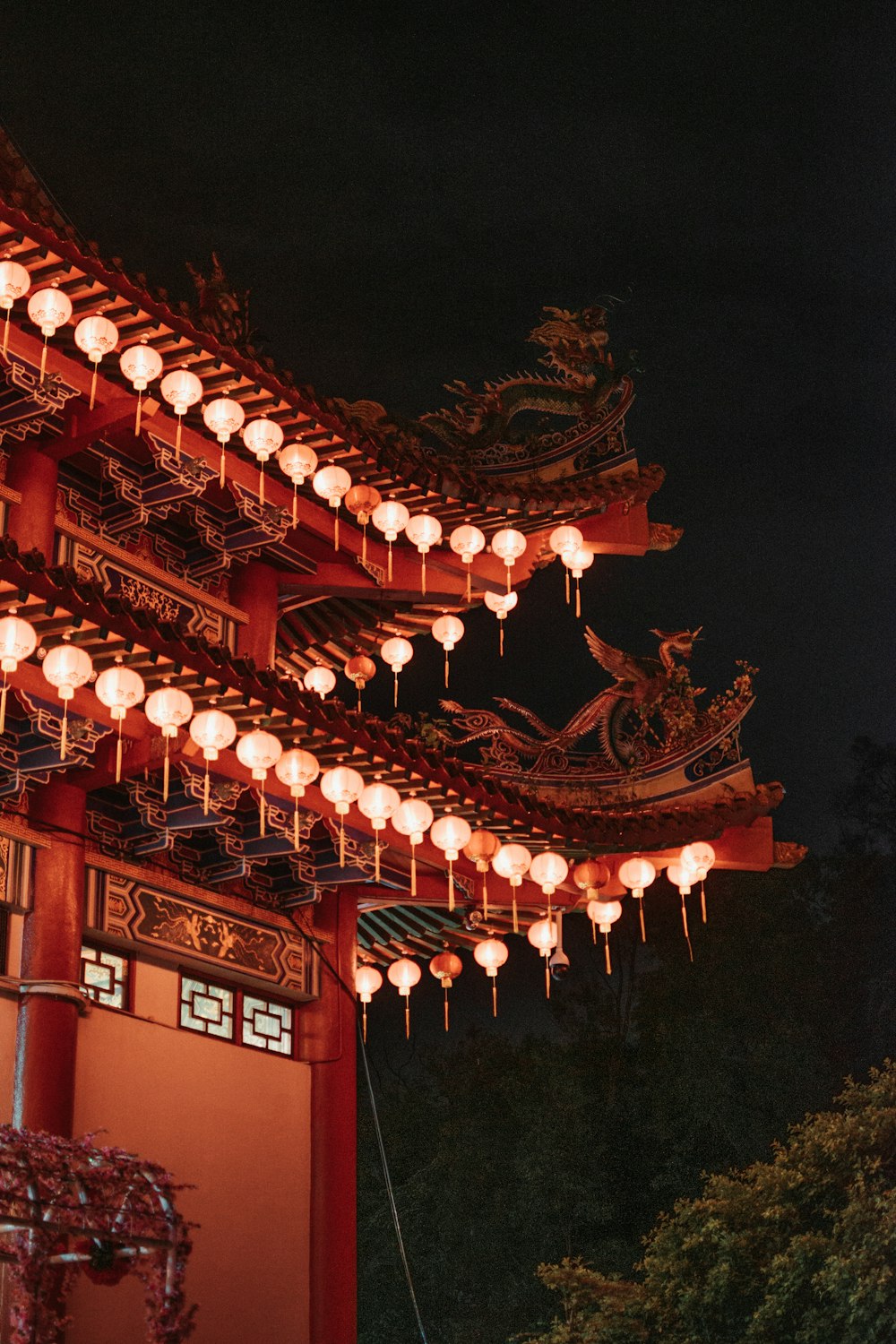 a chinese building with lanterns hanging from it's roof